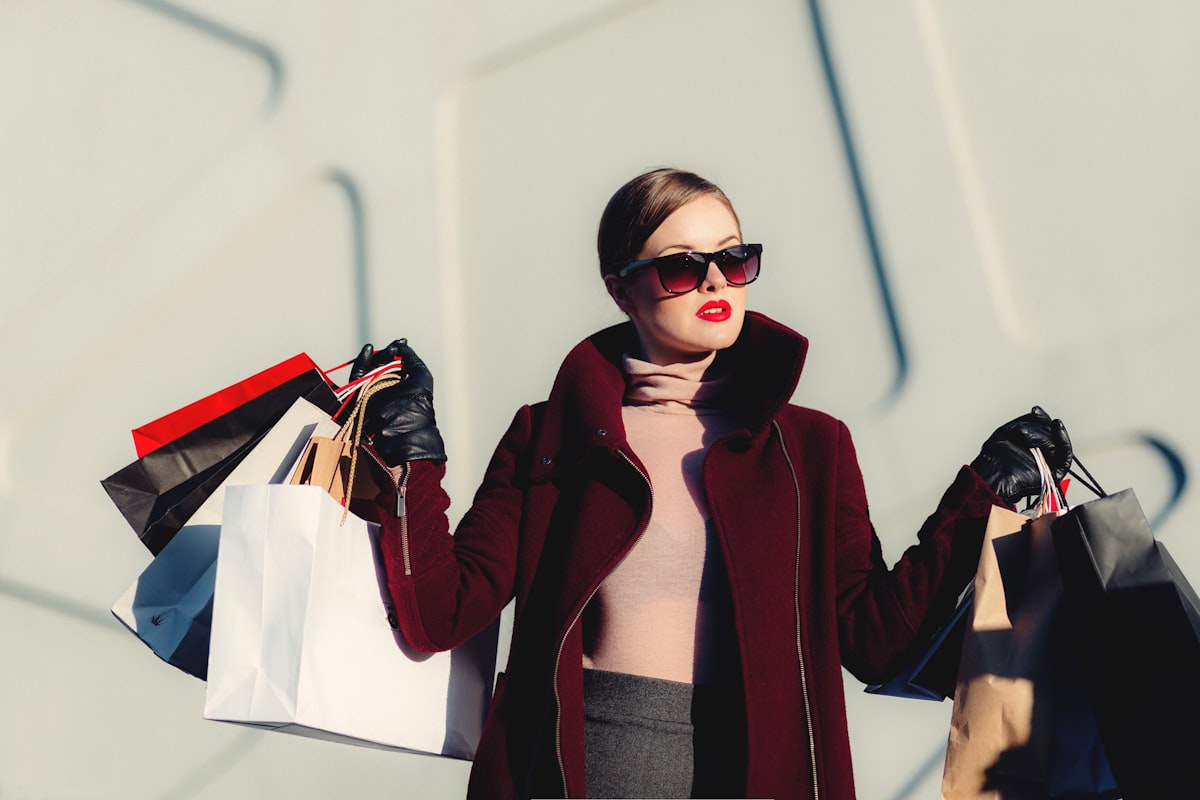 Cliente da FASHION BRAS segurando sacolas de compras ao ar livre